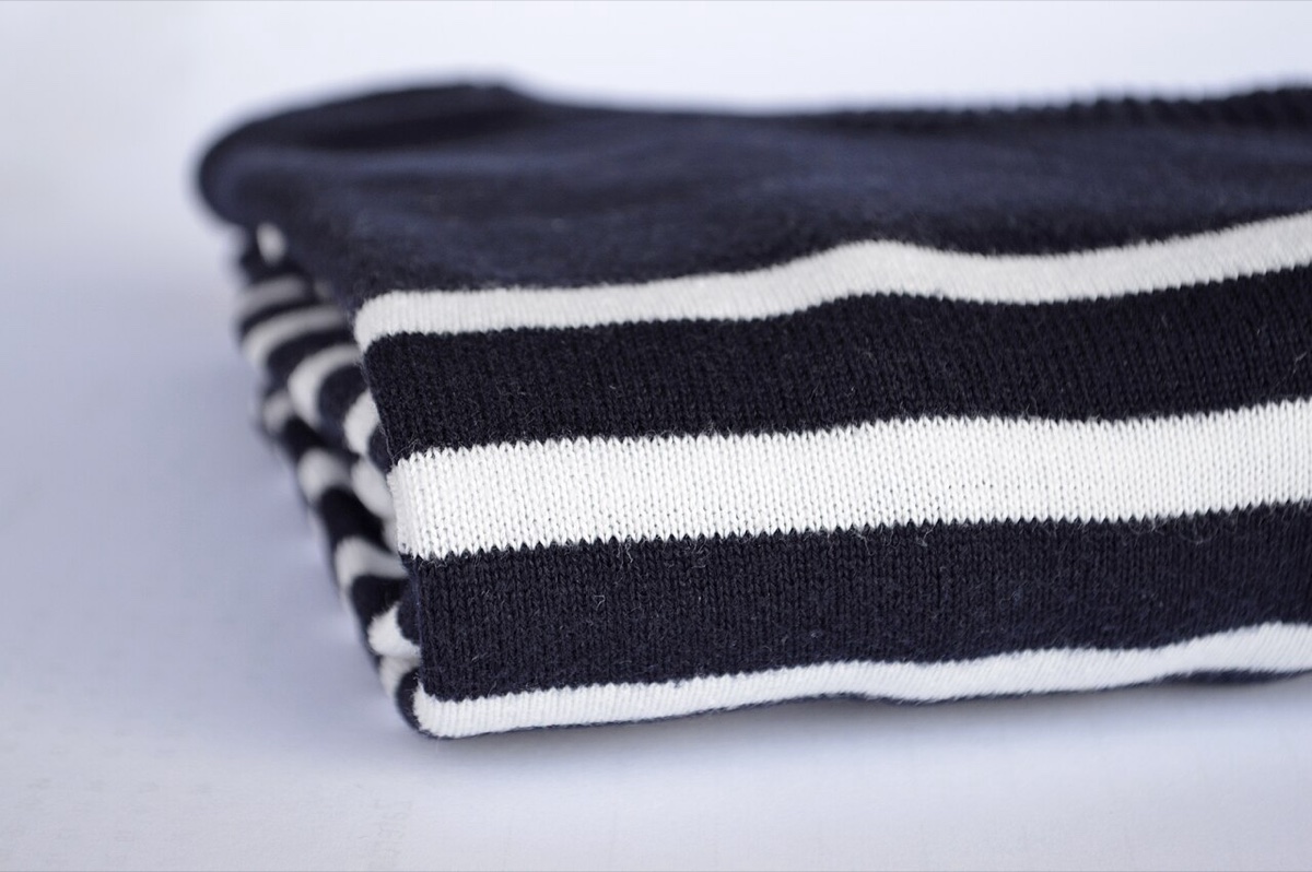 Close-up of a folded navy and white Breton striped sweater