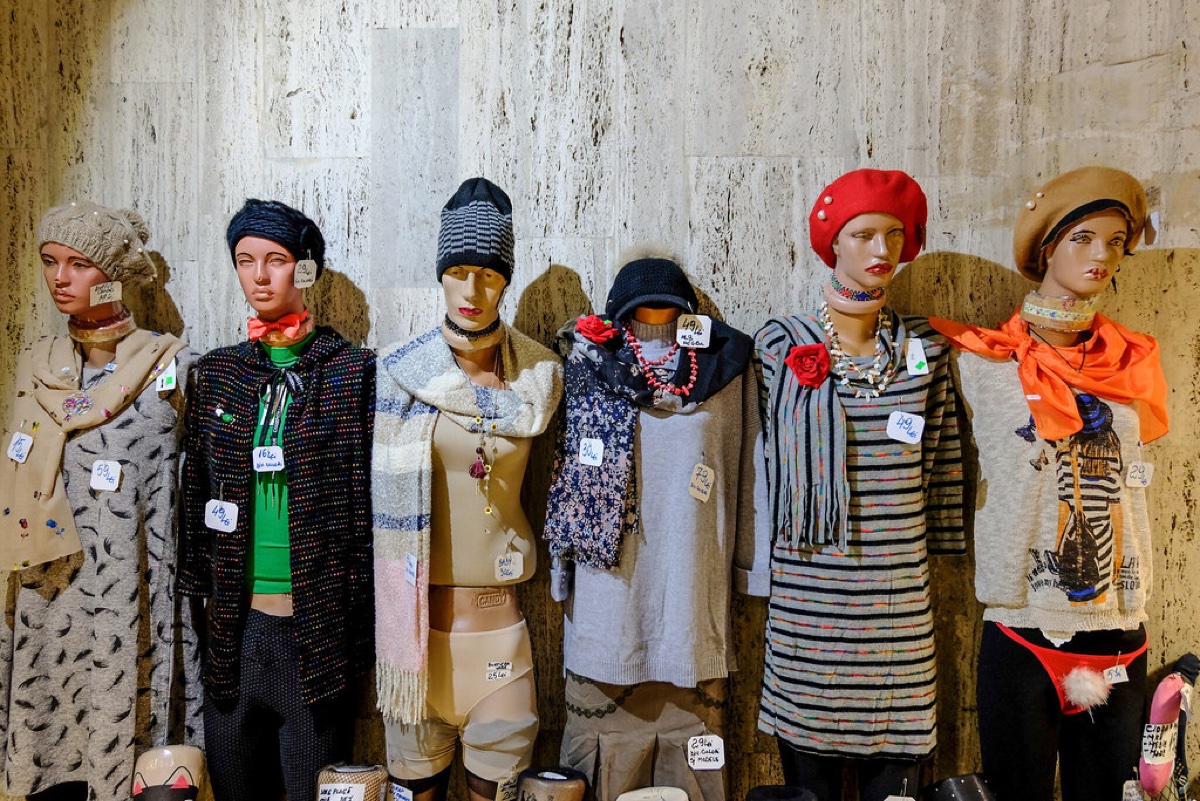 Six thrift-store mannequins in berets, scarves and fall knits, each wearing a handwritten price tag