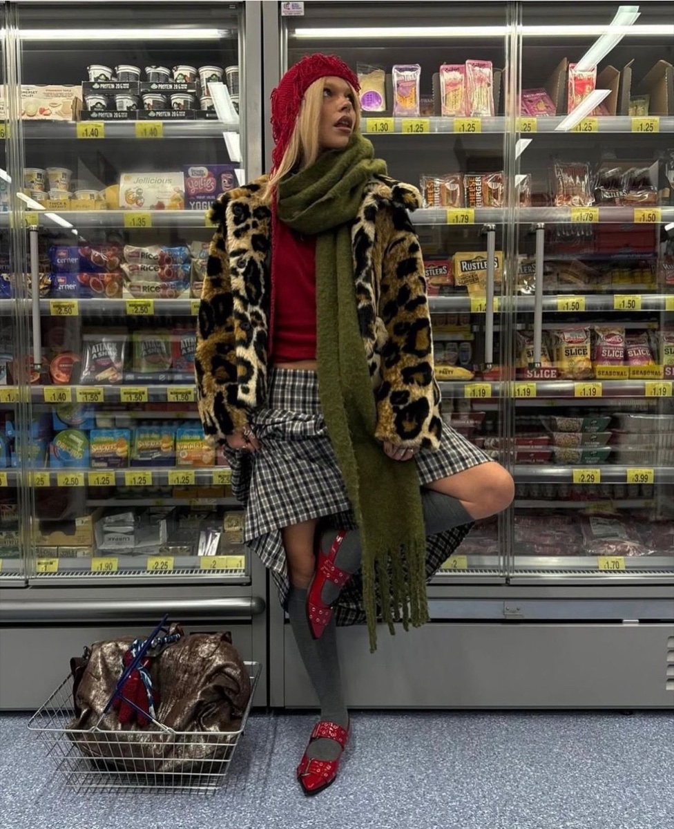 A leopard faux-fur jacket with a green scarf and crochet hat, shot in front of a UK supermarket chiller