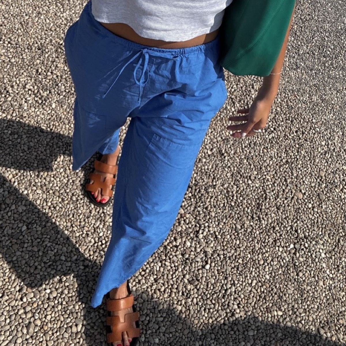 The Kyoto pant in cobalt, drawstring front, shot from above on gravel