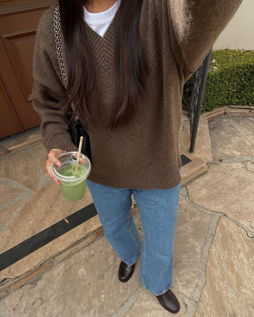 The brown V-neck worn loose over a white tee, jeans and loafers
