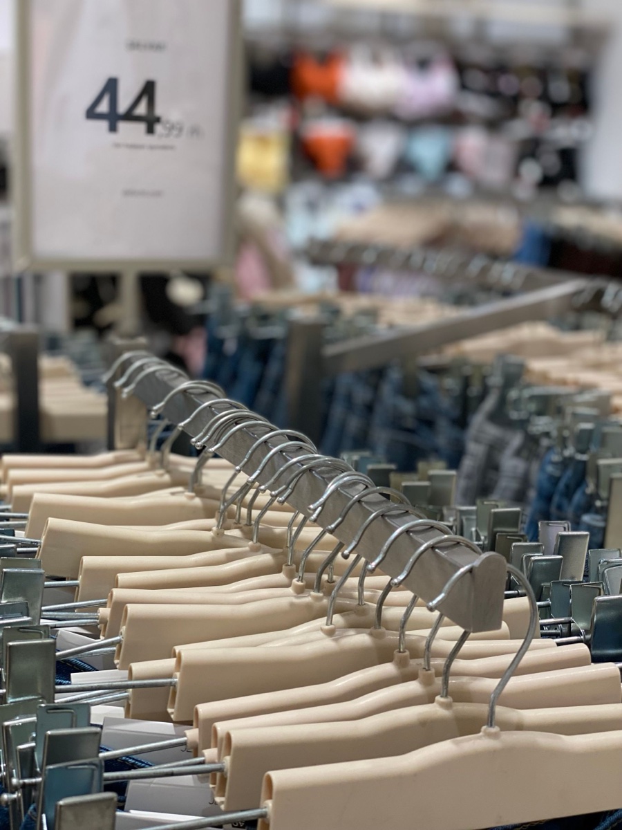 Rows of beige clip hangers on a store rack with a 44.99 price sign in the blurred background
